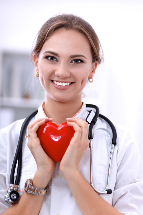 young female nurse holding a heart shape object