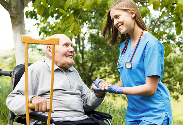 Elderly man with crutches talking with nurse
