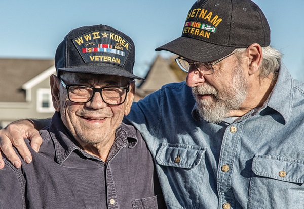 two male veterans hugging and smiling for photo