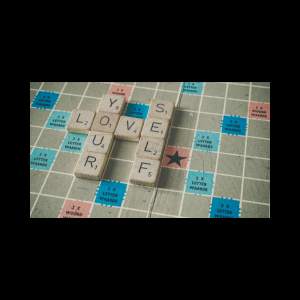scrabble board image with words spelling love yourself